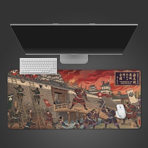 以下が含まれることがあります： 日本の様式のイラストが描かれた長方形のマウスパッド。城門を突破する侍の姿が描かれています。赤、茶色、青の色合いで、白いキーボードとマウスが見えます。