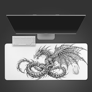 Peut inclure: Un tapis de souris rectangulaire blanc avec une illustration détaillée d'un dragon noir. Un clavier, une souris et un écran d'ordinateur blancs sont également visibles. Le design du dragon présente des détails complexes d'ailes et d'écailles.