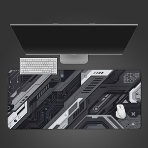 May include: A rectangular desk mat featuring a dark grey and white geometric pattern with intricate circuit board lines, diagonal panels, and abstract shapes. The mat is positioned under a white computer keyboard and a white computer mouse.