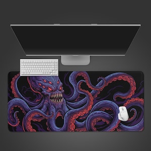 May include: A large rectangular desk mat featuring a dark purple and black illustration of a multi-eyed, sharp-toothed octopus creature with long, winding tentacles. The mat is positioned under a white computer keyboard and a white computer mouse.