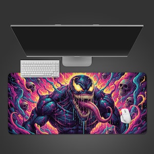 Könnte beinhalten: Ein großes, rechteckiges Mauspad mit einer lebendigen Illustration von Venom, einer Comicfigur. Das Design zeigt Venom mit einer langen Zunge, umgeben von Totenköpfen und farbenfrohen, wirbelnden Mustern in Lila, Blau und Gelb. Eine weiße Maus und Tastatur sind sichtbar.