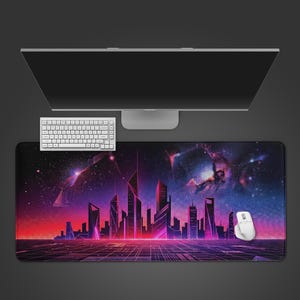 May include: A large rectangular mouse pad featuring a futuristic cityscape design with a grid foreground and a vibrant gradient of red, purple, and blue hues. A white keyboard, mouse, and computer monitor are visible.