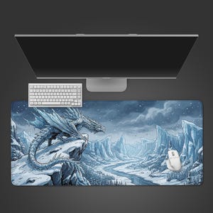 Könnte beinhalten: Ein großes rechteckiges Mauspad mit einer detaillierten Illustration eines weißen Drachen, der auf einer schneebedeckten Klippe über einer Winterlandschaft sitzt. Eine weiße Tastatur, Maus und Computermonitor sind ebenfalls sichtbar.