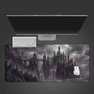 May include: A monochrome mouse mat depicting a gothic castle landscape with waterfalls and stormy skies. A white keyboard and mouse are on the mat, with a computer monitor above.