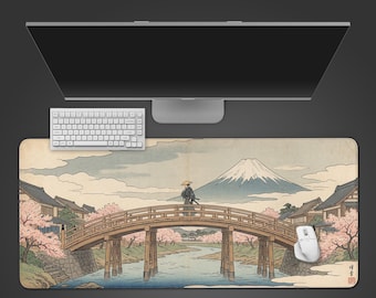 May include: A rectangular desk mat featuring a Japanese landscape with a bridge, a figure, and Mount Fuji. A white keyboard and mouse are positioned above the mat. The mat's design includes cherry blossoms and traditional buildings.