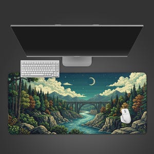 May include: A large rectangular desk mat featuring a pixelated landscape with a river, bridge, and forest under a night sky with a crescent moon. A white keyboard and mouse are on the mat, with a computer monitor above.