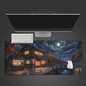 May include: A large rectangular desk mat featuring a nighttime illustration of a traditional Japanese street scene with a ramen stall, wooden buildings, a stone bridge over a canal, and a full moon in a cloudy sky, placed under a computer monitor.