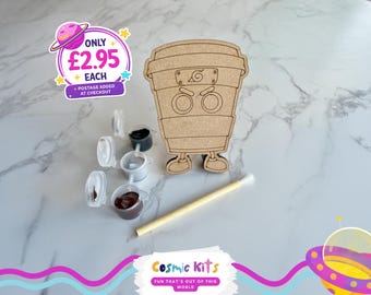Puede incluir: Un kit de manualidades de madera con forma de taza de café con una cara de dibujos animados, botes de pintura y un pincel. El kit incluye el texto "Cosmic Kits" y "FUN THAT'S OUT OF THIS WORLD".