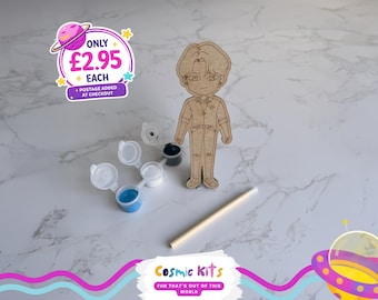 Puede incluir: Un kit para pintar uno mismo con una figura de madera, botes de pintura y un pincel. El kit incluye pintura azul, blanca, negra y gris. La figura de madera es de una persona con gafas. De Cosmic Kits.