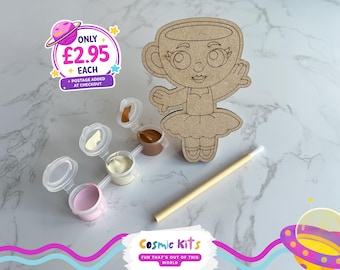 Puede incluir: Un kit de manualidades de madera con un personaje en forma de taza de té, botes de pintura y un pincel. El kit incluye pinturas rosa, beige y marrón. El texto "Cosmic Kits" y "FUN THAT'S OUT OF THIS WORLD" son visibles.