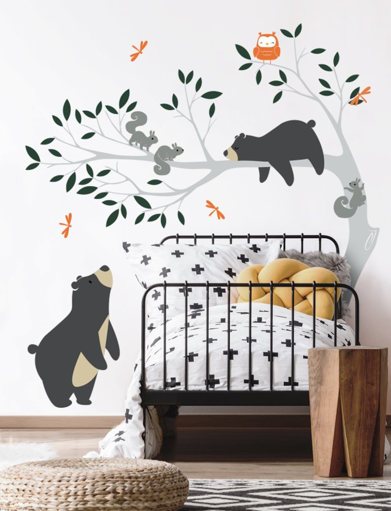 May include: A black and white nursery wall decal featuring a tree with a sleeping bear, two standing bears, and squirrels. The decal also includes a red owl and orange dragonflies.