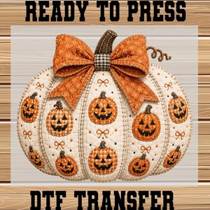 May include: A white quilted pumpkin transfer featuring orange jack-o'-lanterns, small orange bows, and a large orange patterned bow on top. The text READY TO PRESS DTF TRANSFER is visible at the top and bottom of the image in black block letters.