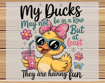 May include: A DTF transfer featuring a cartoon duck wearing sunglasses and a pink bow, holding a drink. The text reads "My Ducks May not be in a Row But at least They are having fun."