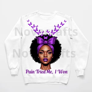 Puede incluir: Sudadera blanca con un gr&aacute;fico de una mujer con una diadema y un lazo morados, rodeada de mariposas moradas. El texto "Pain Tried Me, I Won" est&aacute; impreso debajo de la imagen. El dise&ntilde;o est&aacute; centrado en la parte delantera de la parte superior de manga larga.