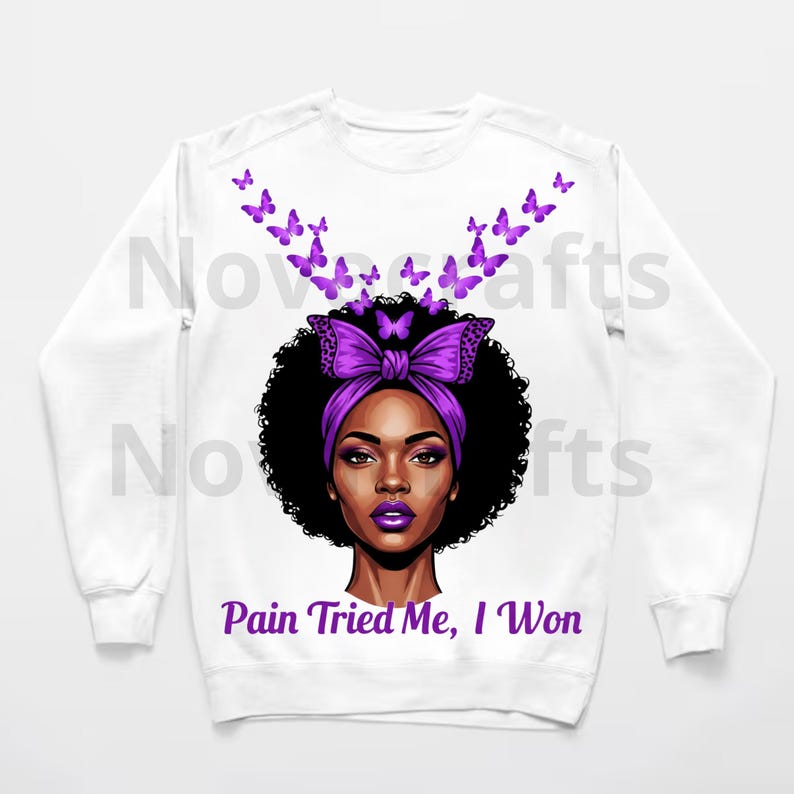 Puede incluir: Sudadera blanca con un gr&aacute;fico de una mujer con una diadema y un lazo morados, rodeada de mariposas moradas. El texto "Pain Tried Me, I Won" est&aacute; impreso debajo de la imagen. El dise&ntilde;o est&aacute; centrado en la parte delantera de la parte superior de manga larga.