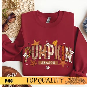 Peut inclure: Un sweat-shirt bordeaux avec l'inscription "PUMPKIN SEASON" dans un design sur le thème de l'automne. Les lettres présentent des motifs léopard, à carreaux et floraux. Le design comprend des étoiles, des feuilles et de petites fleurs blanches.