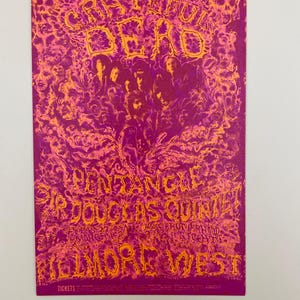 May include: A vintage concert poster for the Grateful Dead, featuring a psychedelic design in shades of purple and orange. The poster includes the band's name, the venue, and the names of the opening acts. The text is stylized with a unique font.