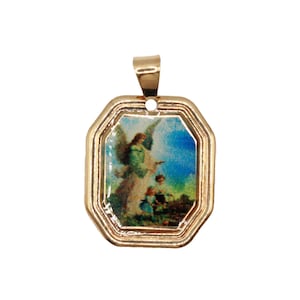 May include: A gold-toned metal pendant with an octagonal frame featuring a central rectangular image of an angel standing over two small children in a landscape setting. The pendant includes a polished gold bail at the top for attachment.