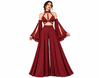 Könnte beinhalten: Ein tiefburgunderrotes zweiteiliges Outfit bestehend aus einer hoch taillierten Hose mit weitem Bein und einem passenden Bralette-Oberteil. Das Oberteil hat einen Ausschnitt im Geschirr-Stil mit Metallringen und lange, abnehmbare Ärmel.