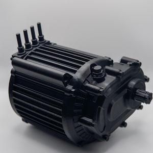 Op de afbeelding: Een zwarte elektromotor met een cilindrisch lichaam en meerdere uitstekende connectoren. De motor heeft een geribbeld ontwerp en een tandwielkast aan één uiteinde. Het object staat tegen een effen witte achtergrond.