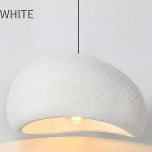 May include: White, textured, pendant light fixture with a curved, organic shape. The light fixture is suspended from a black cord and has the text "B - WHITE" in the upper left corner.
