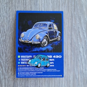 Può includere: Una carta blu con un'illustrazione blu chiaro di un'auto d'epoca. La carta include testo con un numero WhatsApp, loghi di Facebook e Vintec e testo italiano che promuove accessori. L'auto è un Maggiolino blu chiaro.