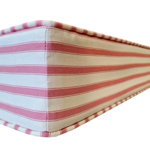 A thick firm foam bench seating cushions made to measure in the UK using materials from other UK based companies. Firm supportive seating foam with a bench cushion cover made with Ian Mankin ticking stripe fabric for a traditional country chic kitchen look. Light pink and cream stripe fabric kitchen bench cushion with velcro straps or anti slip cloth with piping at the edges for a neat finish. Option for hand made button tufting finish, zip at the back for cleaning, stain resistant option.