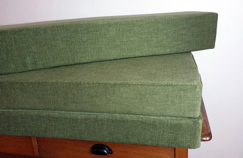 A set of cushions for a campervan conversion in a thick, durable fire retardant green fabric. Wipe clean sleeping cushions for camper van renovation. Made to measure in the UK by a smally family business. Locally sourced materials. Stowaway bed cushions, sprinter bed system cushions. Firm upholstery foam inners with memoryy foam toppers and velcro strips to keep cushions in place. Durable performance fabrics for long lasting camper van cushions. Made to measure, any shape or size, thickness