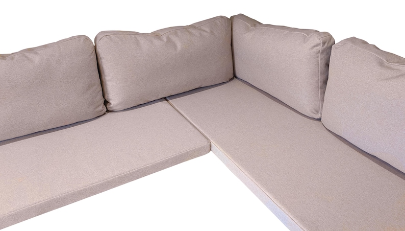 A made to measure banquette seating set - thin firm foam indoor bench cushions with clean, unpiped edges in a light beige coloured wool look fabric that is hard wearing, easy clean and machine washable. Back cushions in soft sofa style filling hollowfibre and duck feather comfortable thick back pads. Bespoke dining room banquette corner seat cushions made in UK. No piping at the edges. Zipper at the back of each bench cushion cover. Neutral coloured bench cushion, griege, fawn coloured fabric