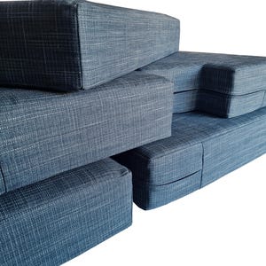 A set of thick, comfortable memory foam and firm foam camper van cushions with long zips at the back and bench cushion covers in linen look, hard wearing teal blue colour fabric. Machine washable camper van cushion covers, easy wash, stain resistant, pet safe, dog friendly. Made to measure, shaped, cut out corners to fit around van walls. Pull out bed mattress cushions high quality, long lasting. Camper van conversion cushions, renovation, motorhome bedding, velcro, straps, eyelet, screw nails