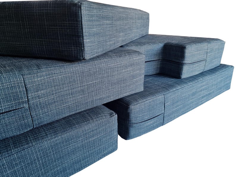 A set of thick, comfortable memory foam and firm foam camper van cushions with long zips at the back and bench cushion covers in linen look, hard wearing teal blue colour fabric. Machine washable camper van cushion covers, easy wash, stain resistant, pet safe, dog friendly. Made to measure, shaped, cut out corners to fit around van walls. Pull out bed mattress cushions high quality, long lasting. Camper van conversion cushions, renovation, motorhome bedding, velcro, straps, eyelet, screw nails