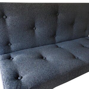 An indoor bench cushion and back cushion for a dining banquette seating area. Thick medium density foam with stockinette wrap seat cushion with a wipe clean woven upholstery fabric cover in a dark blue black colour. Button tufted cushions hand made in hard wearing fabric. Matching back cushion for seating booth. Made in the UK. Shaping - cut outs for arms, angles, trapezoid window seat cushions. Thick firm bench cushions with velcro to keep cushion in place. Hanging bar, anti slip base, zipper