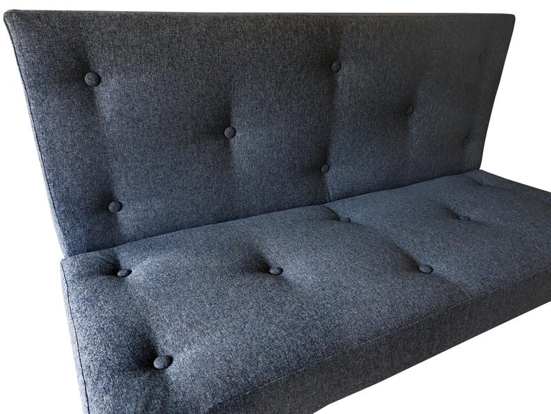 An indoor bench cushion and back cushion for a dining banquette seating area. Thick medium density foam with stockinette wrap seat cushion with a wipe clean woven upholstery fabric cover in a dark blue black colour. Button tufted cushions hand made in hard wearing fabric. Matching back cushion for seating booth. Made in the UK. Shaping - cut outs for arms, angles, trapezoid window seat cushions. Thick firm bench cushions with velcro to keep cushion in place. Hanging bar, anti slip base, zipper