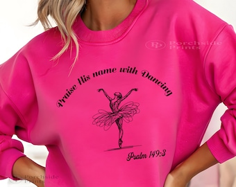 May include: A hot pink sweatshirt with the text "Praise His name with Dancing" and "Psalm 149:3" in black script. A black line drawing of a ballerina is centered below the text. The sweatshirt has a crew neck and long sleeves.