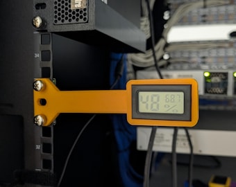 May include: An orange digital temperature and humidity sensor is mounted on a black server rack. The display shows 48% humidity and 68.7 degrees. The sensor is attached with screws.