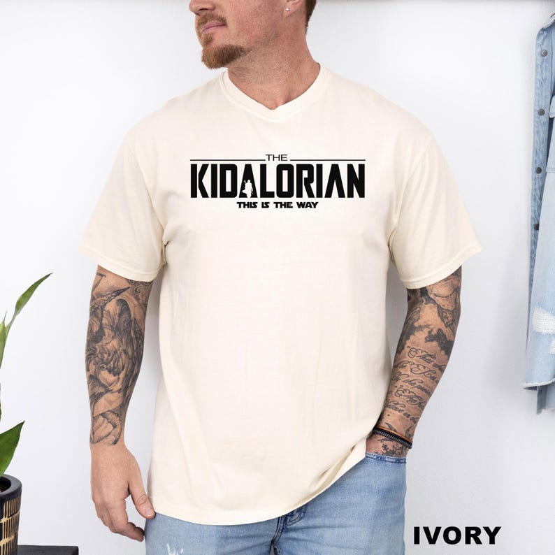 A man wearing a white t-shirt with the text "THE KIDALORIAN THIS IS THE WAY" printed on it.