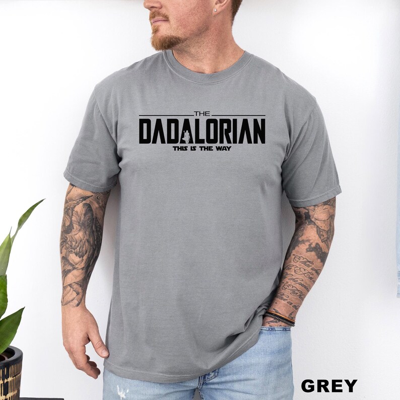 A man wearing a grey t-shirt with the text "THE DADALORIAN THIS IS THE WAY" printed on it.