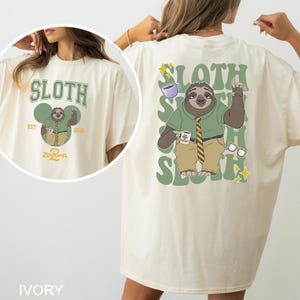 A woman wearing a white t-shirt with a cartoon sloth character and text printed on it.