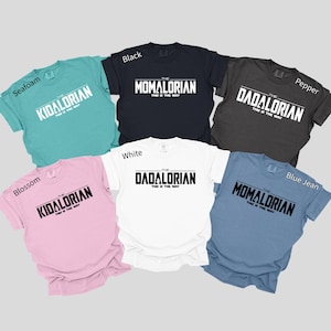 a collection of seven T-shirts, each with a different color and design, featuring the text "The Dadalorian" printed on them.