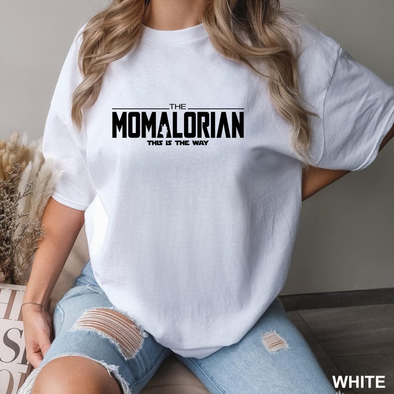 A person wearing a white t-shirt with the text "THE MOMALORIAN THIS IS THE WAY" printed on it.