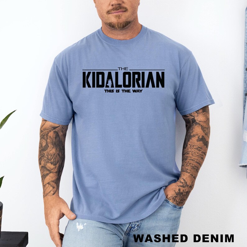 A man wearing a blue t-shirt with the text "THE KIDALORIAN THIS IS THE WAY" printed on it.