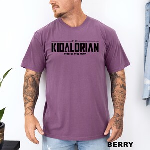 A man wearing a purple t-shirt with the text "THE KIDALORIAN THIS IS THE WAY" printed on it.