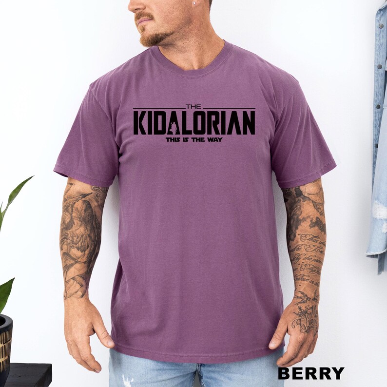A man wearing a purple t-shirt with the text "THE KIDALORIAN THIS IS THE WAY" printed on it.