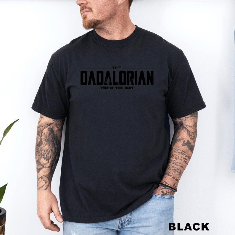 A man wearing a black t-shirt with the text "THE DADALORIAN THIS IS THE WAY" printed on it.