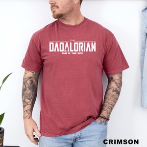 A man wearing a red t-shirt with the text "THE DADALORIAN THIS IS THE WAY" printed on it.