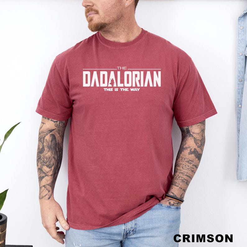 A man wearing a red t-shirt with the text "THE DADALORIAN THIS IS THE WAY" printed on it.