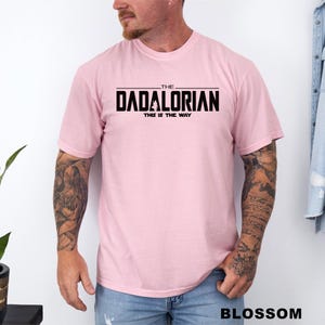 A man wearing a pink t-shirt with the text "THE DADALORIAN THIS IS THE WAY" printed on it.