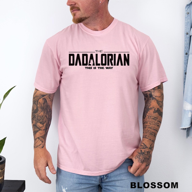 A man wearing a pink t-shirt with the text "THE DADALORIAN THIS IS THE WAY" printed on it.