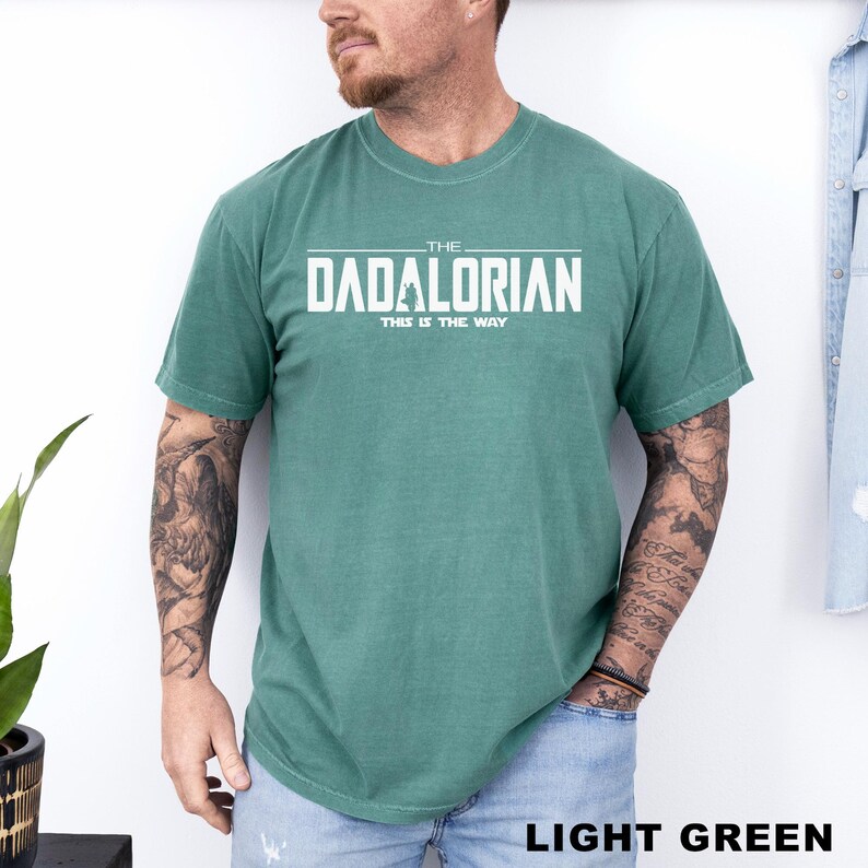 A man wearing a green t-shirt with the text "THE DADALORIAN THIS IS THE WAY" printed on it.
