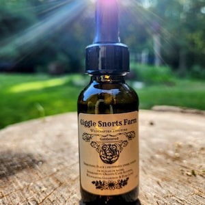 Puede incluir: Una botella de vidrio con un gotero y una etiqueta que dice "Giggle Snorts Farm Wildcrafted Tincture Goldenrod". La botella est&aacute; sobre una superficie de madera.